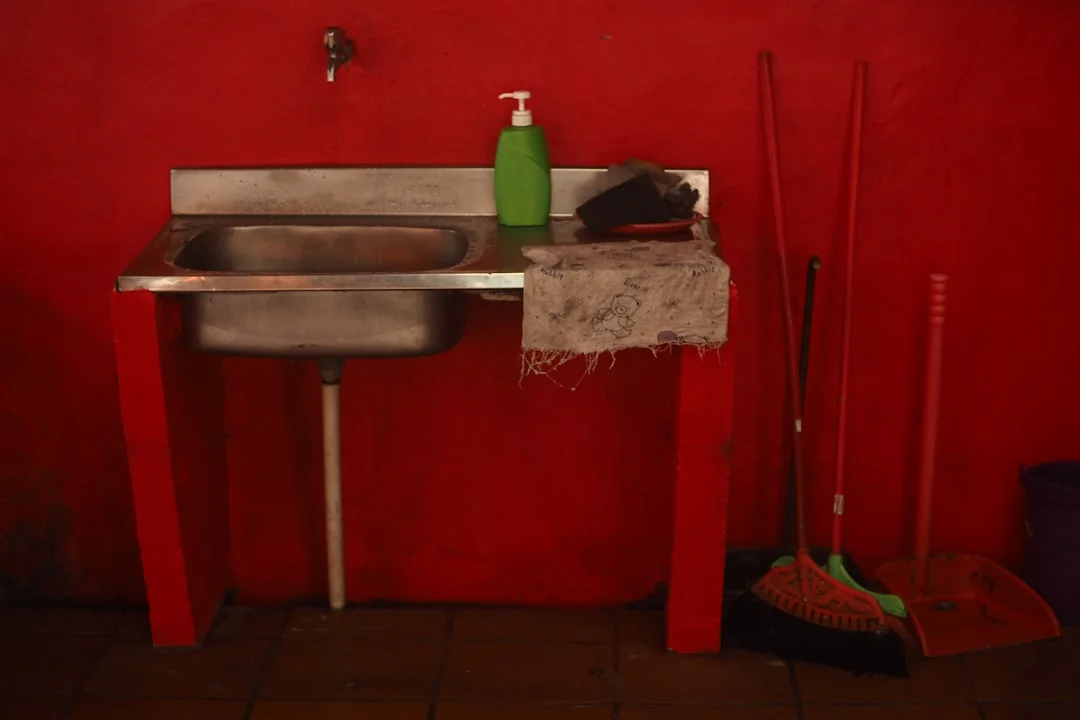 about-us Anonymous person in yellow rubber gloves using simple sponge for cleaning mirror in bathroom